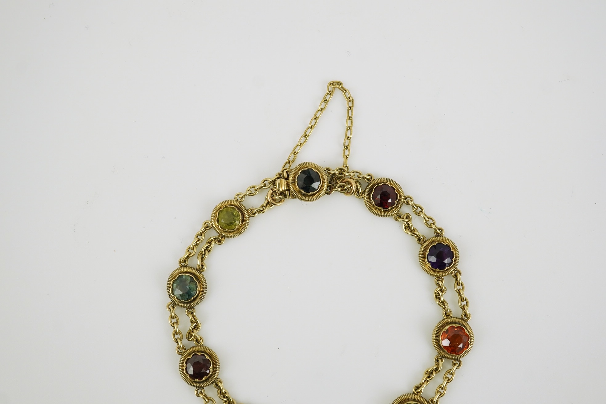 An early 20th century yellow metal and ten stone multi gem set chain link bracelet